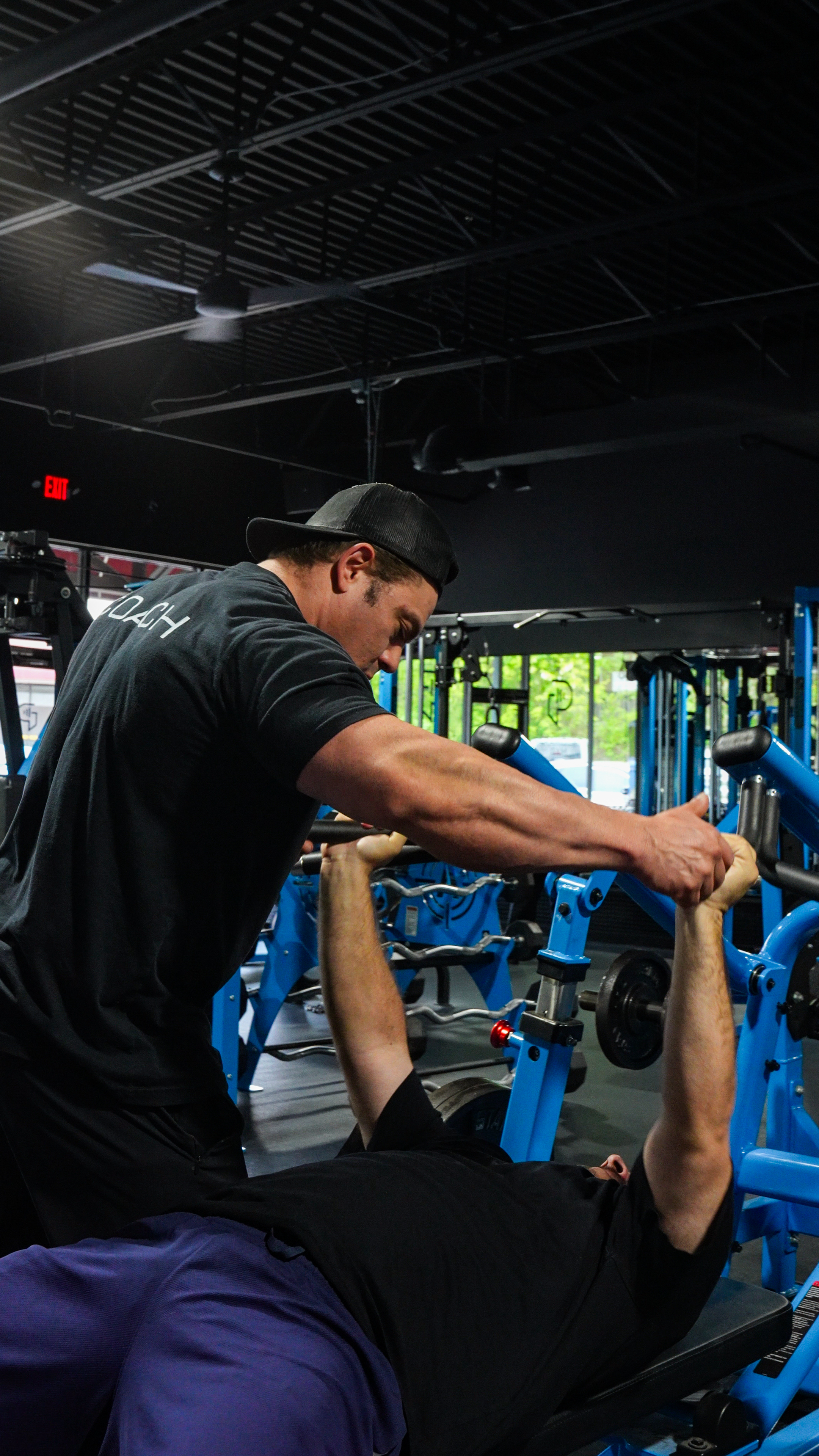 Paramount Gym personal trainer spotting a client